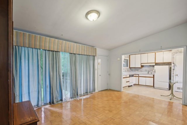 929 Deervale Dr, Nashville, TN 37217 - kitchen with freestanding refrigerator, white cabinetry, decorative backsplash, vaulted ceiling, and light countertops