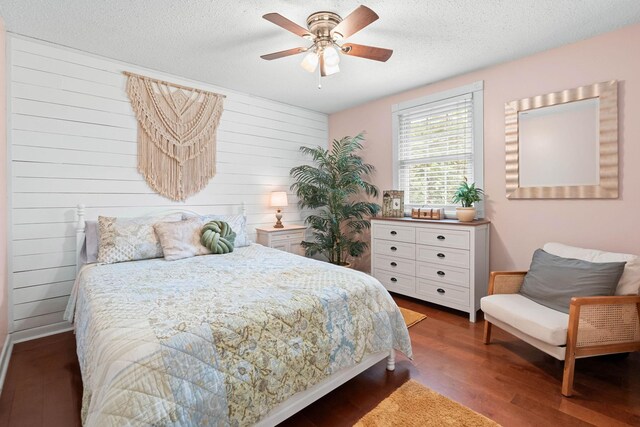 7214 Timberlane Dr, Fairview, TN 37062 - bedroom featuring dark wood-type flooring, a textured ceiling, wooden walls, and a ceiling fan