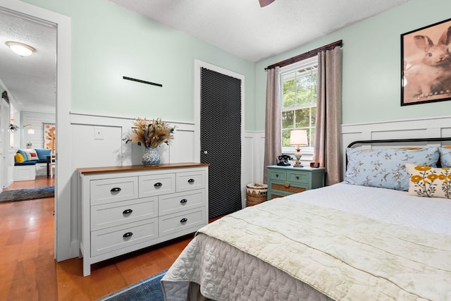 7214 Timberlane Dr, Fairview, TN 37062 - bedroom featuring a textured ceiling, wainscoting, and dark wood-type flooring