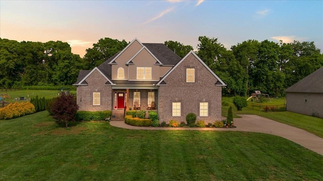 1047 Caballo Trl, Gallatin, TN 37066 - view of front facade with a porch, a yard, brick siding, and concrete driveway