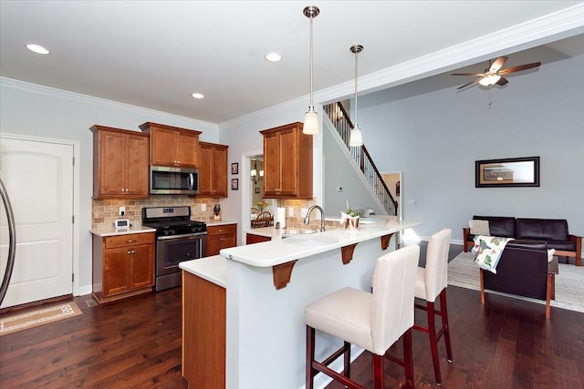 1047 Caballo Trl, Gallatin, TN 37066 - kitchen with appliances with stainless steel finishes, brown cabinets, a breakfast bar, decorative backsplash, and recessed lighting