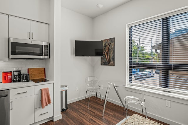 1014 16th Ave S Unit 210, Nashville, TN 37212 - kitchen featuring stainless steel appliances, dark wood-style floors, decorative backsplash, baseboards, and white cabinets