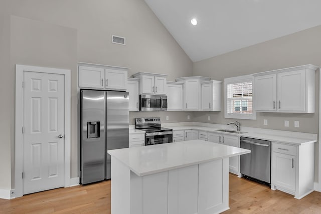 404 Generosity Way, Smyrna, TN 37167 - kitchen with stainless steel appliances, a sink, high vaulted ceiling, white cabinetry, and light countertops