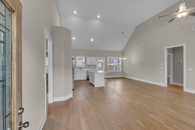 404 Generosity Way, Smyrna, TN 37167 - unfurnished living room with high vaulted ceiling, a ceiling fan, light wood finished floors, a chandelier, and baseboards