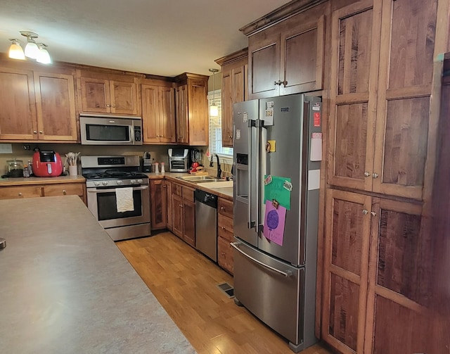 208 Royal Oak Dr, Dickson, TN 37055 - kitchen with appliances with stainless steel finishes, light wood-type flooring, light countertops, and a sink