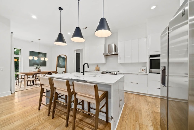 1240 John Windrow Rd, Eagleville, TN 37060 - kitchen with appliances with stainless steel finishes, modern cabinets, wall chimney range hood, white cabinets, and recessed lighting