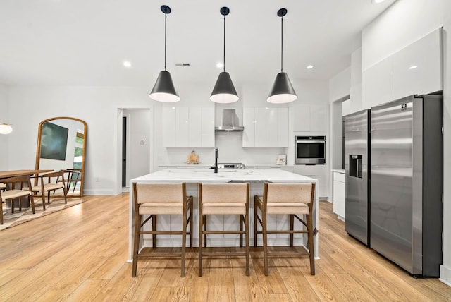 1240 John Windrow Rd, Eagleville, TN 37060 - kitchen with appliances with stainless steel finishes, modern cabinets, white cabinetry, light wood-type flooring, and wall chimney range hood