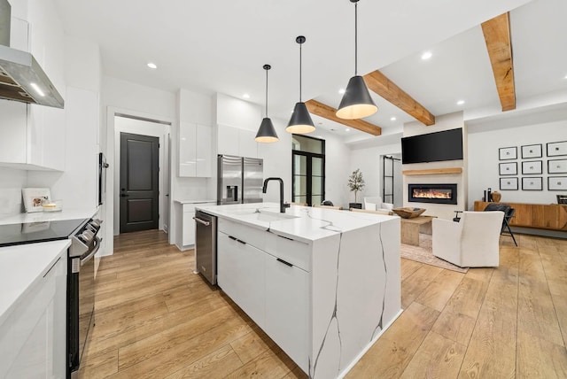 1240 John Windrow Rd, Eagleville, TN 37060 - kitchen with wall chimney range hood, stainless steel appliances, white cabinets, modern cabinets, and beam ceiling