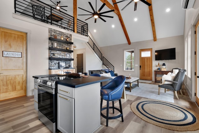 44 Hasty Hill Rd, Lynchburg, TN 37352 - kitchen with stainless steel range with electric cooktop, open floor plan, high vaulted ceiling, dark countertops, and a wall mounted AC