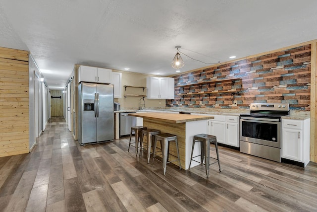 9780 S Lick Creek Rd SW, Lyles, TN 37098 - kitchen featuring stainless steel appliances, open shelves, wooden walls, butcher block counters, and white cabinetry
