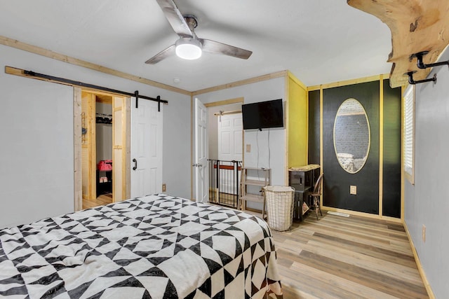 9780 S Lick Creek Rd SW, Lyles, TN 37098 - bedroom featuring light wood-style flooring, a barn door, baseboards, and ceiling fan