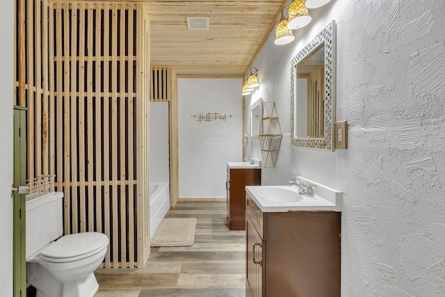 9780 S Lick Creek Rd SW, Lyles, TN 37098 - full bath with wood finished floors, vanity, wood ceiling, toilet, and a textured wall