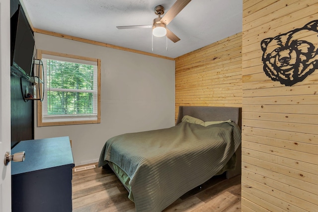 9780 S Lick Creek Rd SW, Lyles, TN 37098 - bedroom featuring wooden walls, wood finished floors, a ceiling fan, and ornamental molding