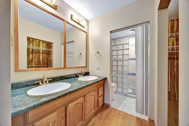 943 Old Ccc Rd, Sewanee, TN 37375 - full bathroom featuring toilet, double vanity, tiled shower, and wood finished floors