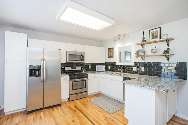 321 Amherst Dr, Murfreesboro, TN 37128 - kitchen featuring stainless steel appliances, white cabinets, light wood-style flooring, tasteful backsplash, and light stone counters