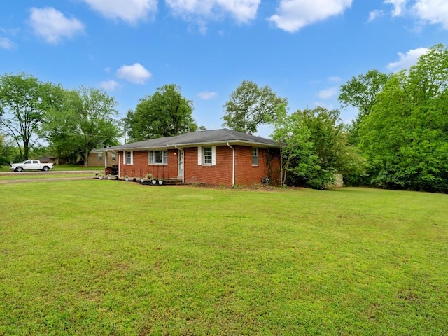 189 Washington Ave, Camden, TN 38320 - back of house featuring a lawn and brick siding