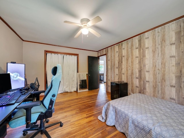 189 Washington Ave, Camden, TN 38320 - bedroom with ornamental molding, wood finished floors, an office area, a ceiling fan, and wood walls