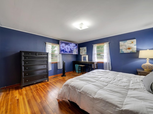 189 Washington Ave, Camden, TN 38320 - bedroom with multiple windows, ornamental molding, wood finished floors, and baseboards