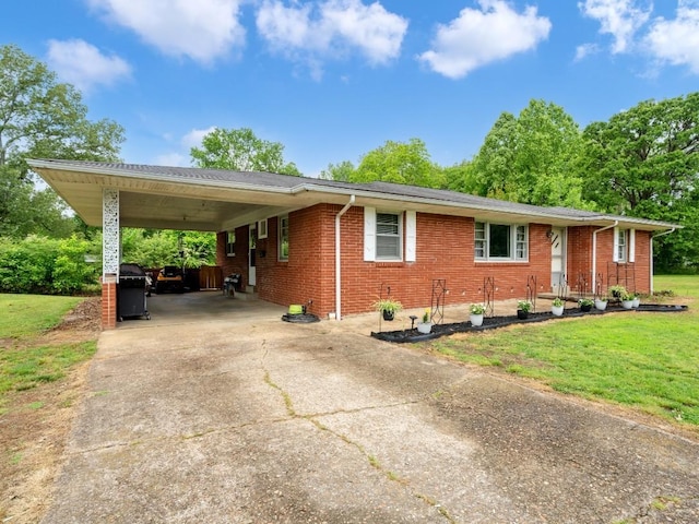 189 Washington Ave, Camden, TN 38320 - view of front of home with concrete driveway, brick siding, a front yard, and a carport