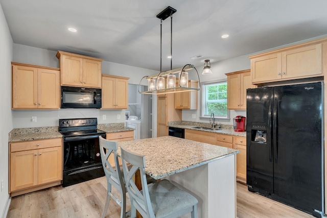 4001 S Windsor Ct, Springfield, TN 37172 - kitchen with black appliances, light brown cabinetry, washing machine and clothes dryer, a sink, and light wood-style floors