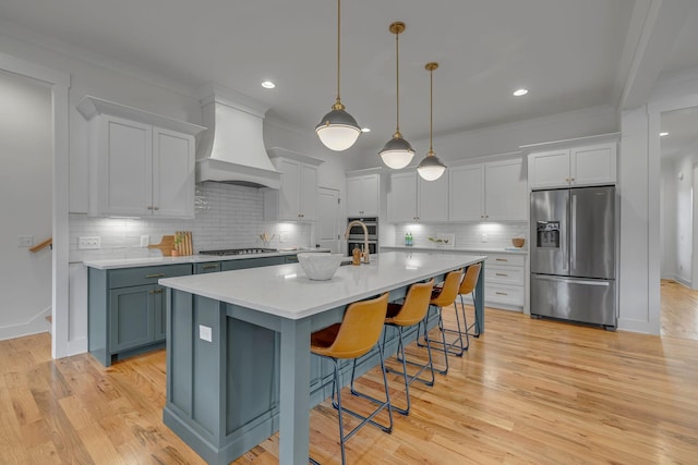 609 Dallas Ct, Murfreesboro, TN 37130 - kitchen with stainless steel appliances, custom exhaust hood, light countertops, decorative backsplash, and an island with sink
