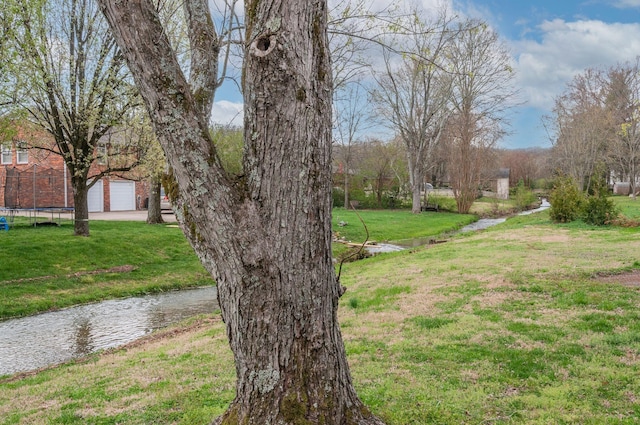 6307 Park Ln, Nashville, TN 37205 - view of grassy yard with a trampoline, driveway, and a garage