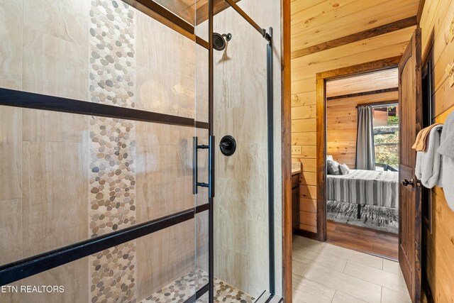 817 Pine Top Ln, Gatlinburg, TN 37738 - ensuite bathroom featuring a shower stall, wooden walls, and tile patterned flooring