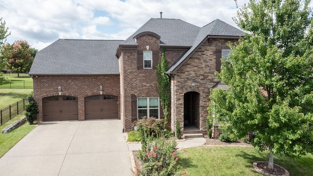 1303 Reynard Dr, Gallatin, TN 37066 - french country inspired facade with driveway, roof with shingles, an attached garage, and brick siding