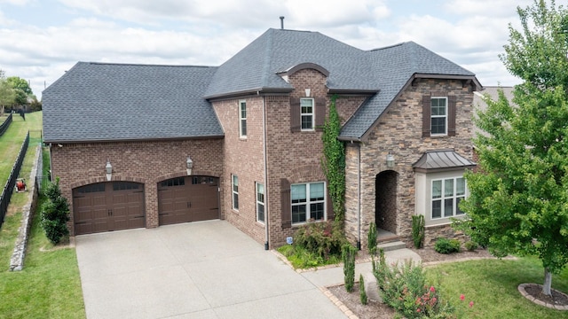 1303 Reynard Dr, Gallatin, TN 37066 - french country style house with a front lawn, concrete driveway, a shingled roof, stone siding, and a garage