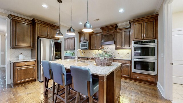 1303 Reynard Dr, Gallatin, TN 37066 - kitchen featuring stainless steel appliances, a sink, custom range hood, decorative backsplash, and hanging light fixtures