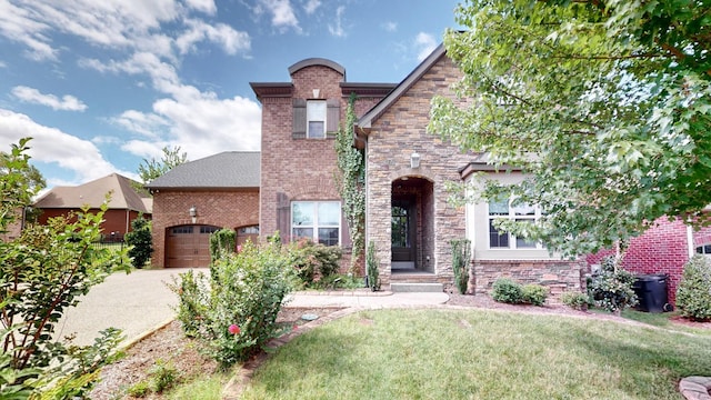 1303 Reynard Dr, Gallatin, TN 37066 - tudor house featuring an attached garage, driveway, stone siding, and a front lawn