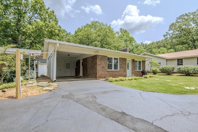 262 Purdy Rd, Selmer, TN 38375 - view of front of home featuring brick siding, a front yard, asphalt driveway, and a carport