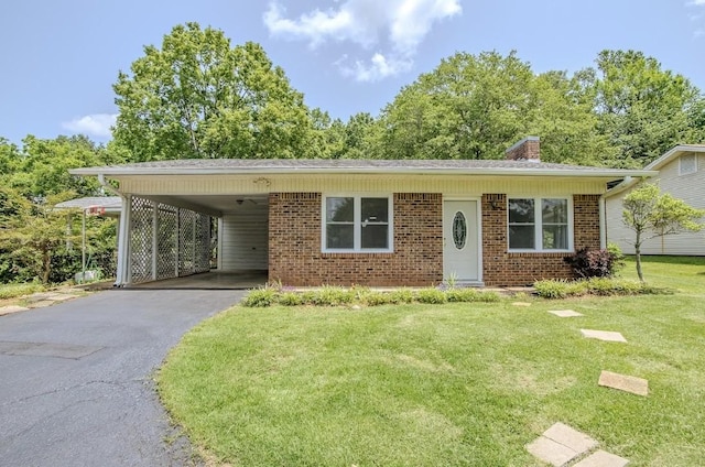 262 Purdy Rd, Selmer, TN 38375 - view of front of home with asphalt driveway, a front lawn, brick siding, a chimney, and a carport