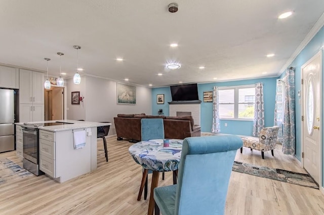 262 Purdy Rd, Selmer, TN 38375 - dining area with ornamental molding, light wood-style flooring, recessed lighting, a brick fireplace, and baseboards