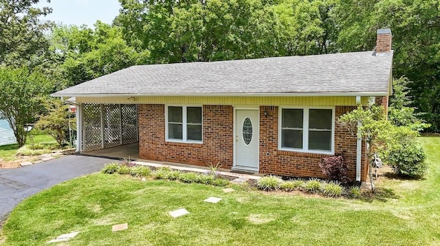 262 Purdy Rd, Selmer, TN 38375 - bungalow with a chimney, an attached carport, a front yard, and brick siding