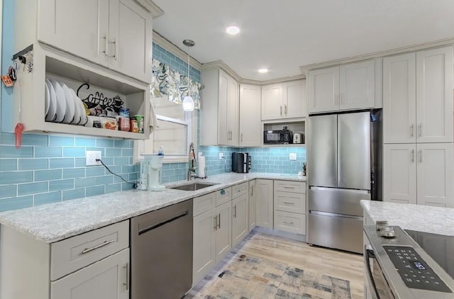262 Purdy Rd, Selmer, TN 38375 - kitchen featuring stainless steel appliances, open shelves, a sink, light wood-style floors, and tasteful backsplash
