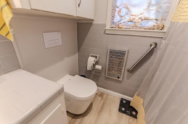 262 Purdy Rd, Selmer, TN 38375 - full bathroom featuring wood finished floors, heating unit, toilet, tile walls, and vanity