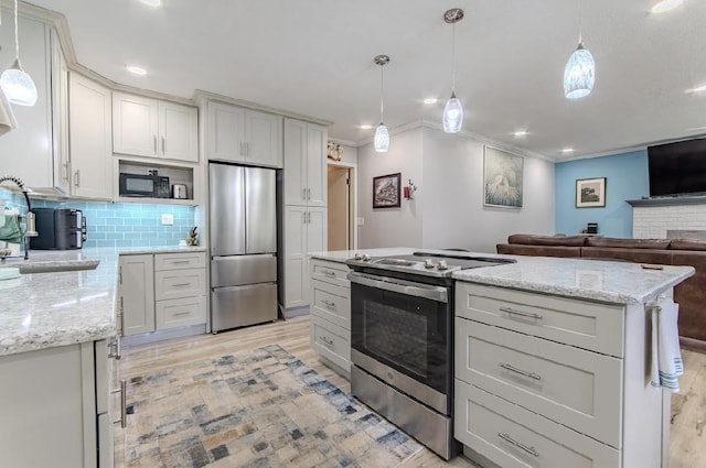 262 Purdy Rd, Selmer, TN 38375 - kitchen featuring appliances with stainless steel finishes, light wood finished floors, ornamental molding, decorative backsplash, and pendant lighting