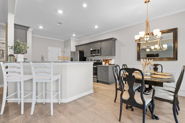 6787 Dharma Loop, Chattanooga, TN 37412 - kitchen with appliances with stainless steel finishes, gray cabinets, ornamental molding, light stone counters, and light wood-style floors