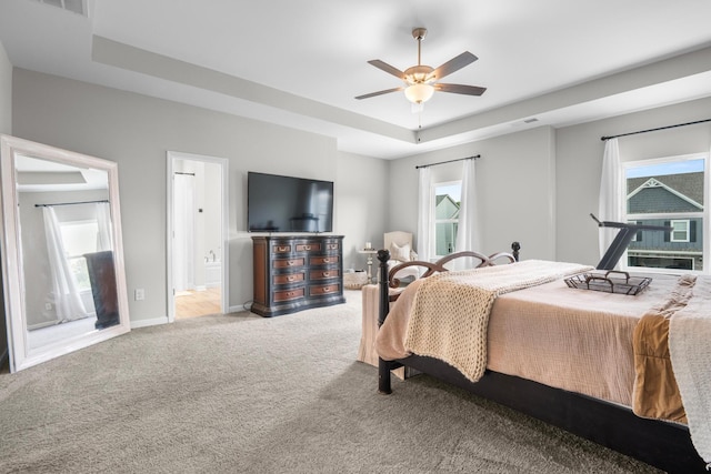 6787 Dharma Loop, Chattanooga, TN 37412 - bedroom featuring a tray ceiling, light colored carpet, baseboards, ensuite bathroom, and a ceiling fan
