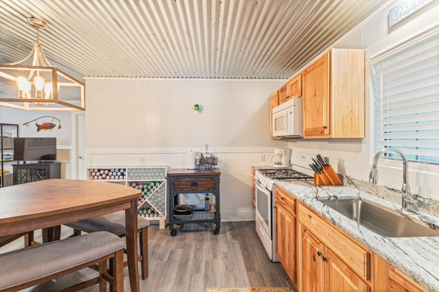 4053 Deer Creek Rd, Linden, TN 37096 - kitchen featuring white appliances, a sink, light stone counters, light wood-style floors, and a chandelier