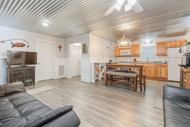 4053 Deer Creek Rd, Linden, TN 37096 - living area featuring a wainscoted wall, ceiling fan, light wood-style floors, and a chandelier