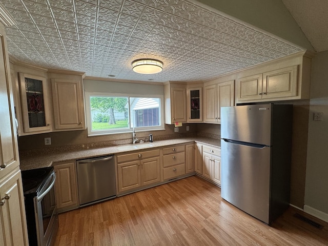 2306 Raspberry Ln, Lebanon, TN 37087 - kitchen featuring appliances with stainless steel finishes, a sink, an ornate ceiling, light wood-type flooring, and glass insert cabinets