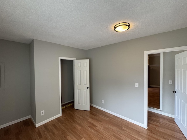2306 Raspberry Ln, Lebanon, TN 37087 - unfurnished bedroom featuring wood finished floors, baseboards, and a textured ceiling