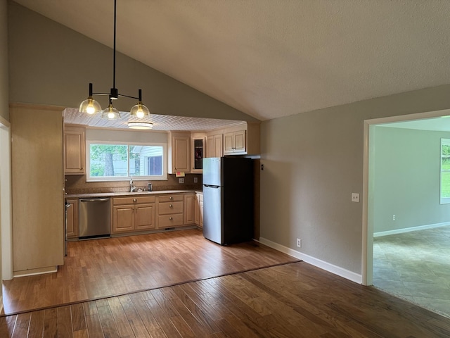 2306 Raspberry Ln, Lebanon, TN 37087 - kitchen with stainless steel appliances, a sink, light brown cabinets, light wood-style floors, and decorative light fixtures
