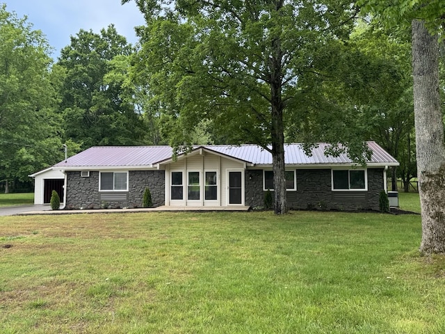 2306 Raspberry Ln, Lebanon, TN 37087 - view of front of house with stone siding, a front yard, an attached garage, and metal roof