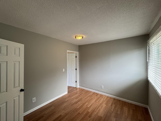 2306 Raspberry Ln, Lebanon, TN 37087 - unfurnished room featuring wood finished floors, baseboards, and a textured ceiling