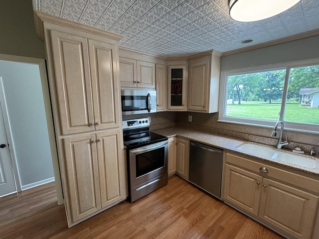 2306 Raspberry Ln, Lebanon, TN 37087 - kitchen with stainless steel appliances, a sink, an ornate ceiling, light wood-style floors, and crown molding