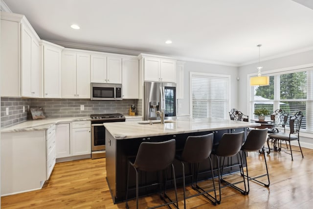 217 Valley Bend Dr, Nashville, TN 37214 - kitchen featuring stainless steel appliances, ornamental molding, a sink, a center island with sink, and decorative backsplash