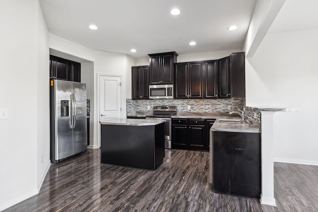 2003 Allerton Way, Spring Hill, TN 37174 - kitchen featuring appliances with stainless steel finishes, a center island, dark wood-style flooring, backsplash, and a sink